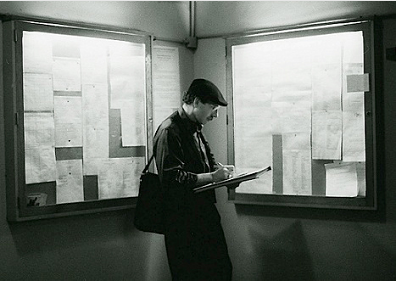 Stanley Roseman noting the schedule of rehearsals, performances, and changes of cast listed on the bulletin boards in a backstage corridor of the Palais Garnier. Photo by Ronald Davis.